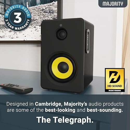 Majority audio speaker with yellow cone and remote control.